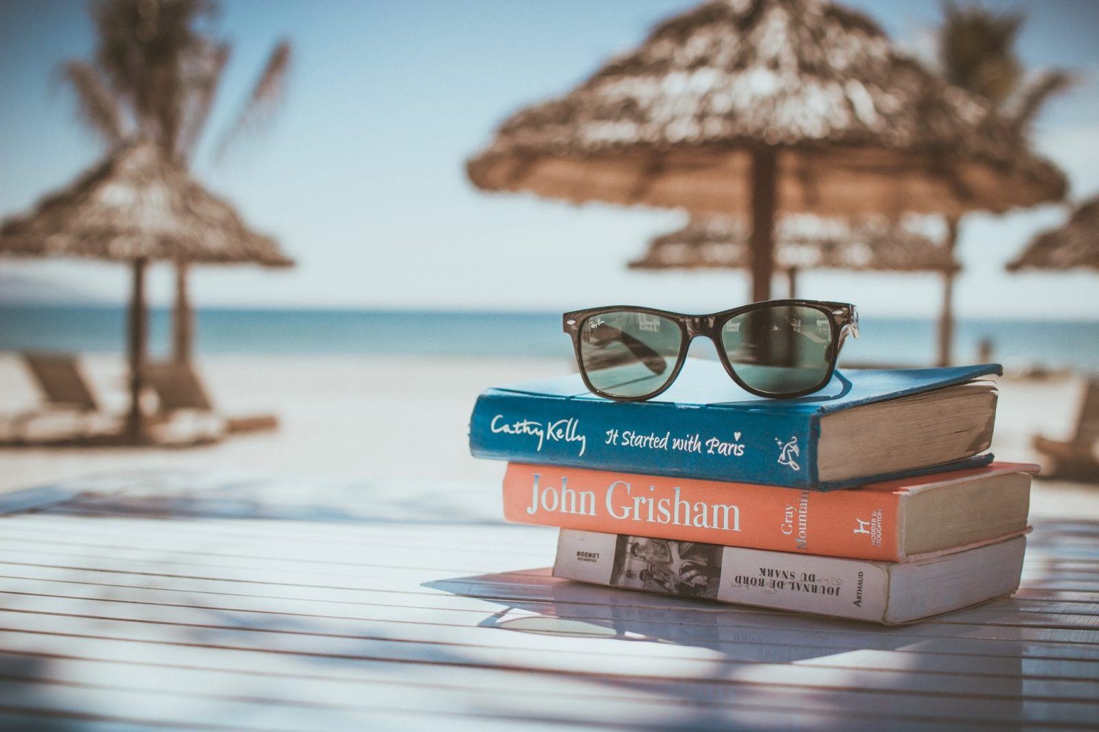 relaxing villa holiday in Bali books on beach with sunglasses bokeh