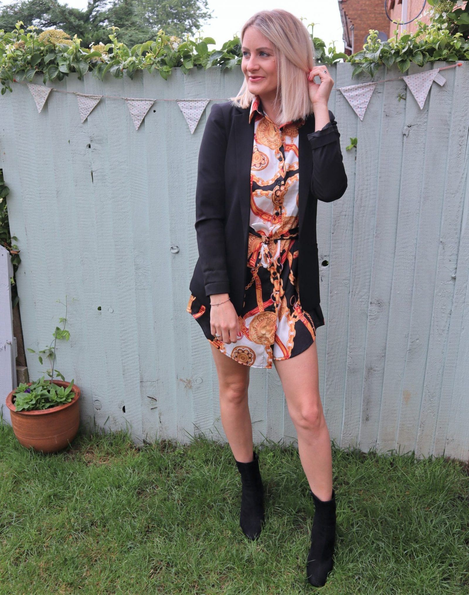 lady in a simple but stylish outfit wearing a chain print dress and a blazer