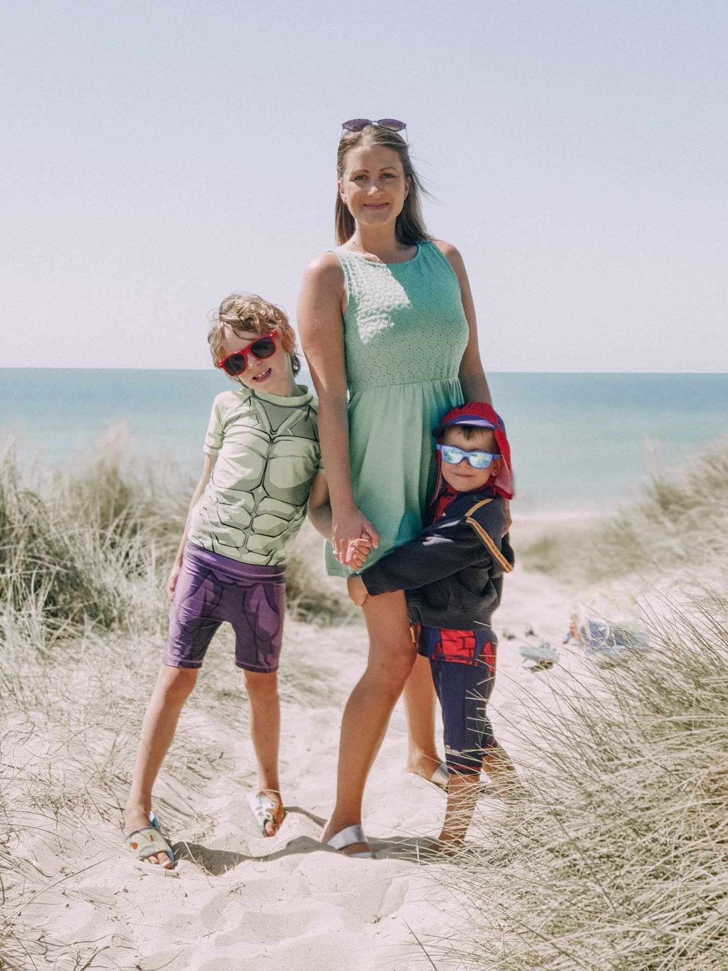 Mum standing with children on pretty beach
