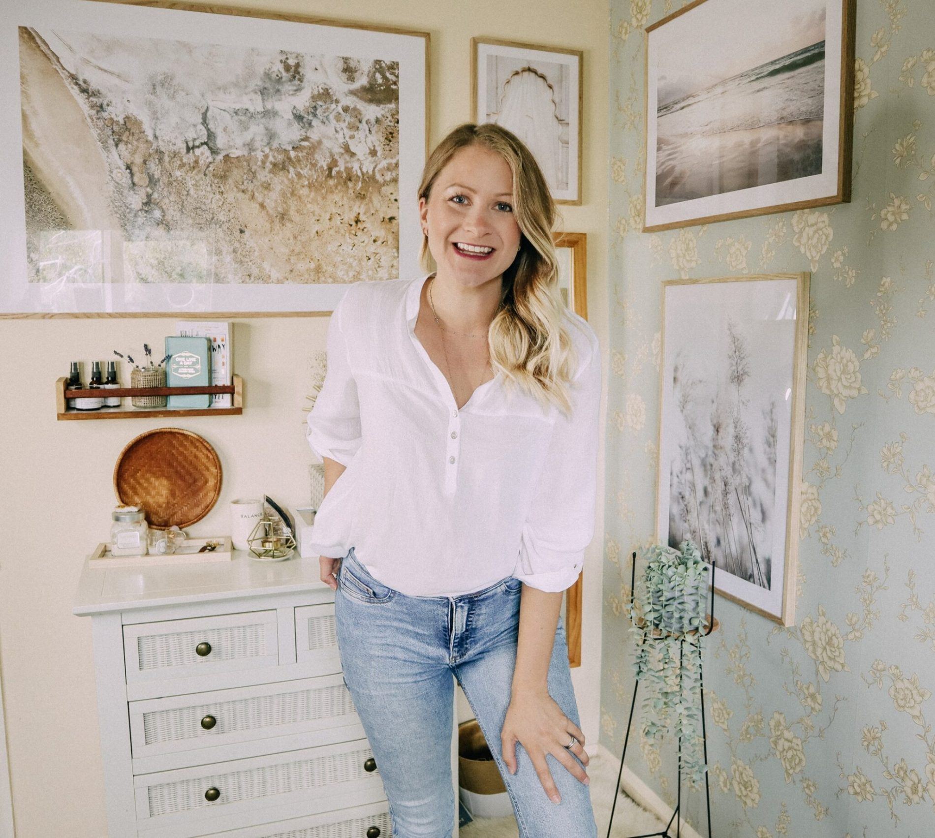 lady smiling stood in front of gallery wall to show decorating your rental