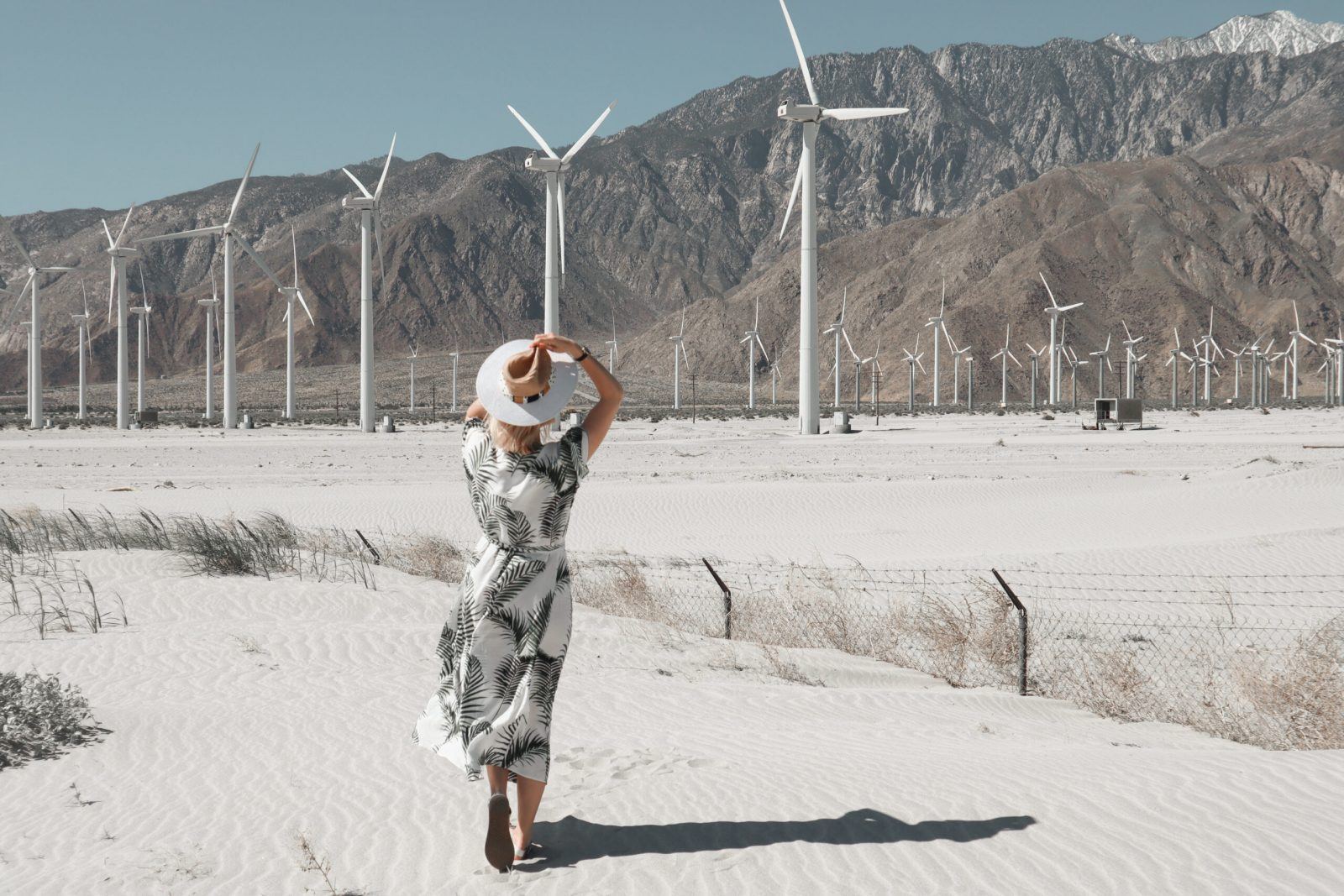 lady facing away from the camera in front of wind turbines
