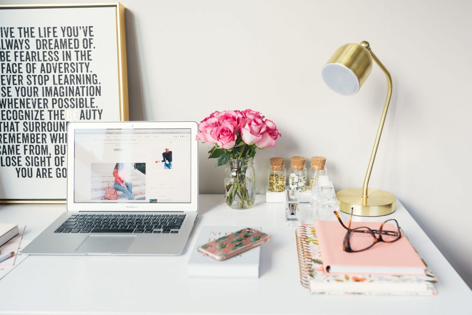 desk layout with flowers, books and glasses