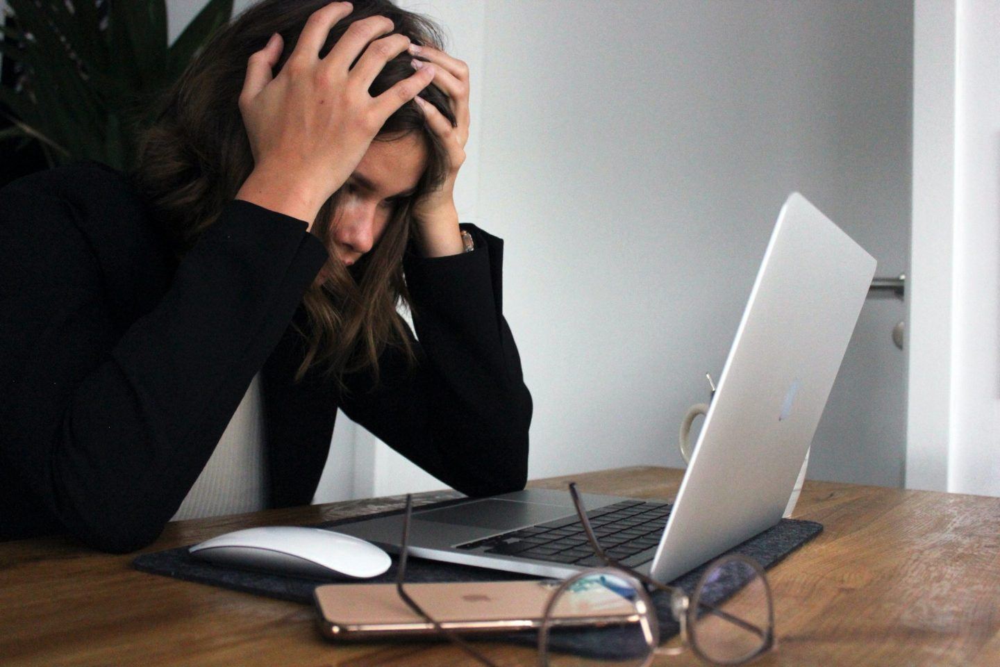 woman looking stressed at laptop with online courses on financial education displayed on the screen, representing the availability of resources to help people improve their financial literacy. woman looking stressed looking at Laptop with online courses on financial education.