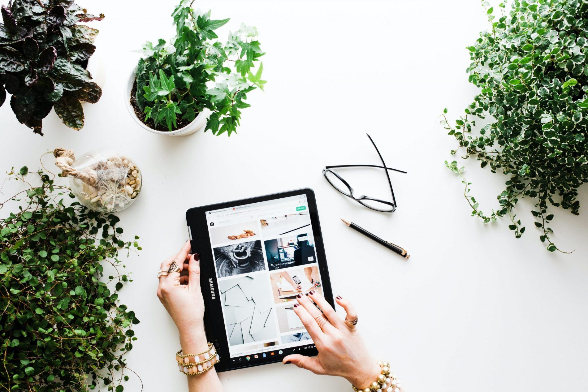 A person looking through images on an iPad, representing the concept of side hustles for saving for a house deposit while paying rent.