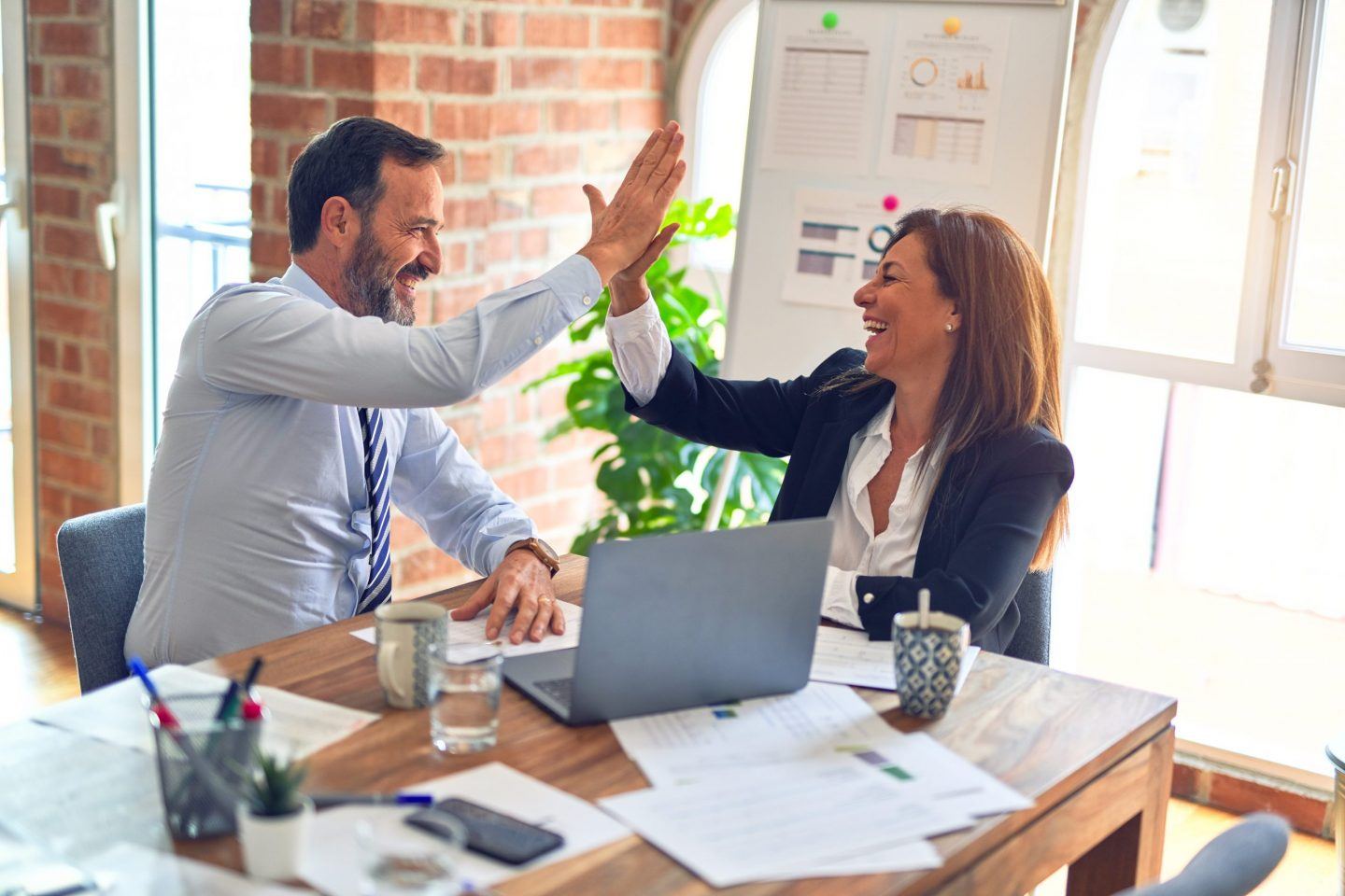 two people high-fiving, representing the FIRE movement and how being frugal and intentional with spending can help with financial freedom